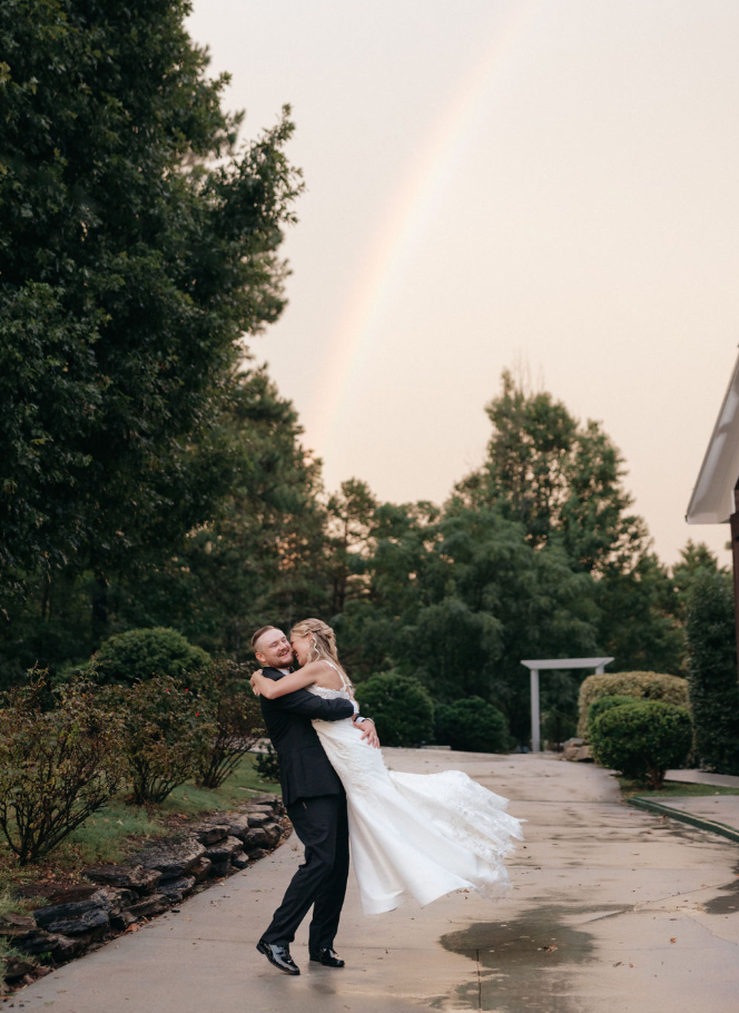 wedding couple in the grounds of Koury Farms with a rainbow in the background